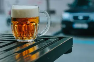 Mrazivé sklo pilsner piva na dřevěném stole v pivní zahradě v Praze, Česká republika.