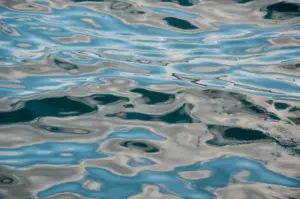 Pokojný pohled na hladinu oceánu, která ukazuje jemné vlnky odrážející oblohu.
